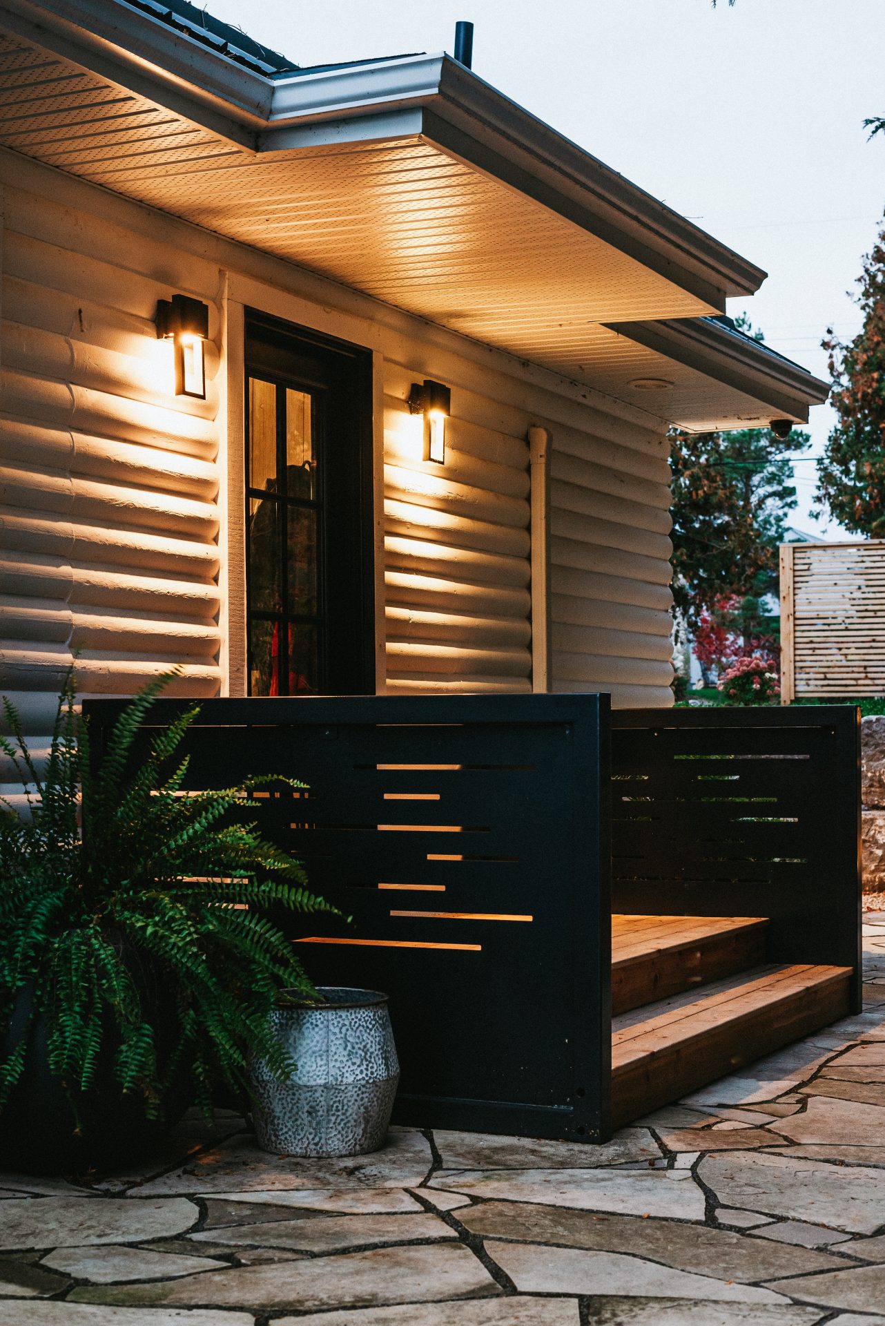 Modern home exterior with lit porch at dusk