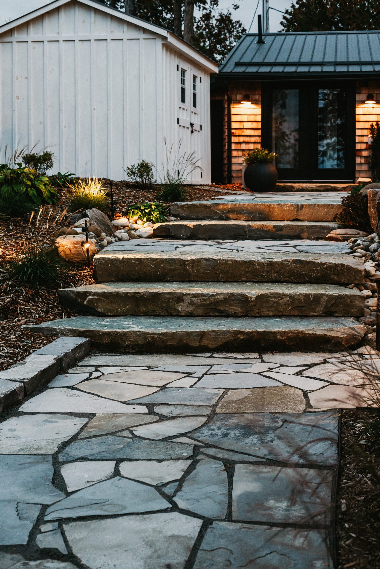 Stone steps leading to modern home entrance at dusk
