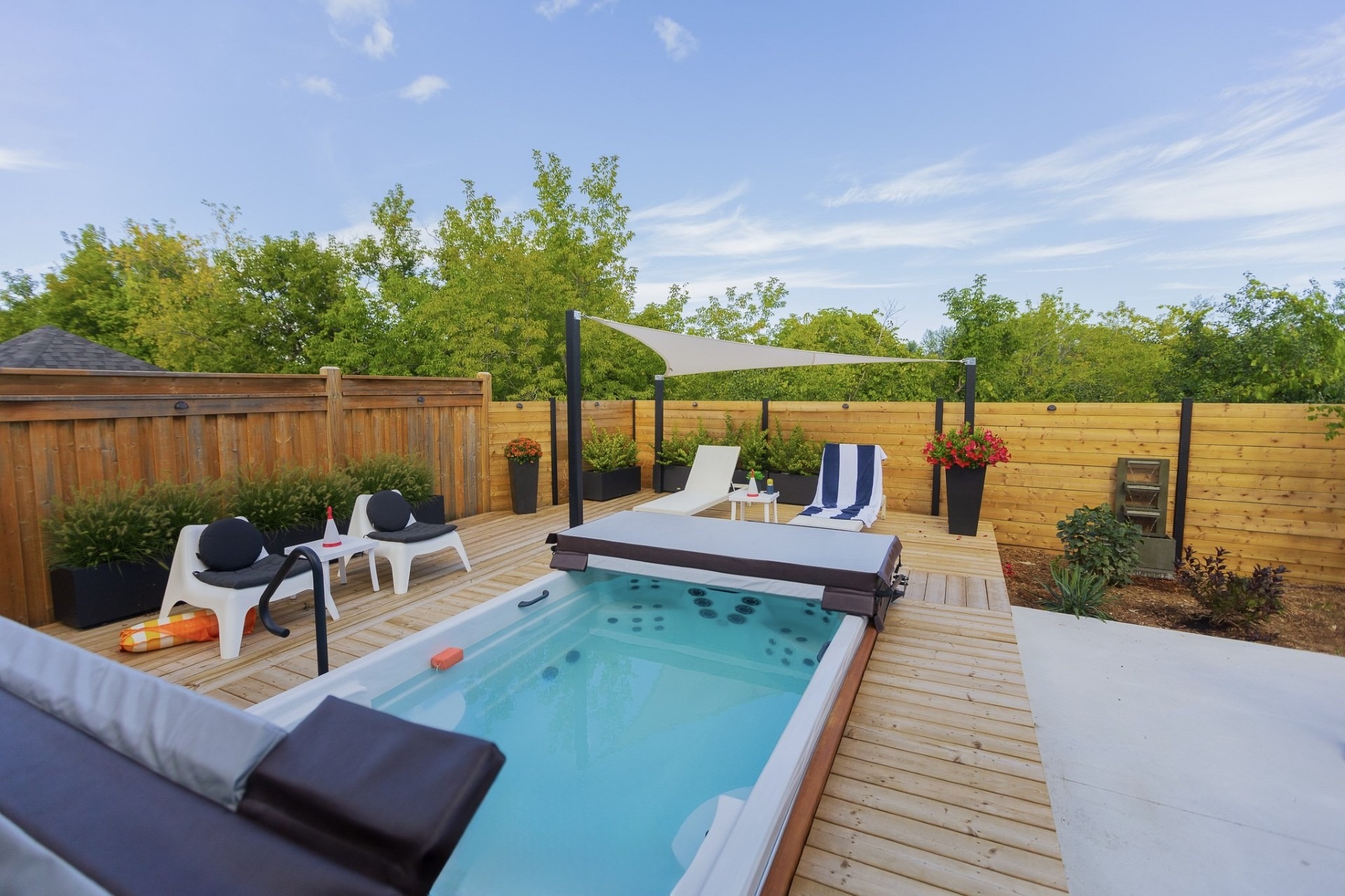Modern backyard deck with small pool and loungers