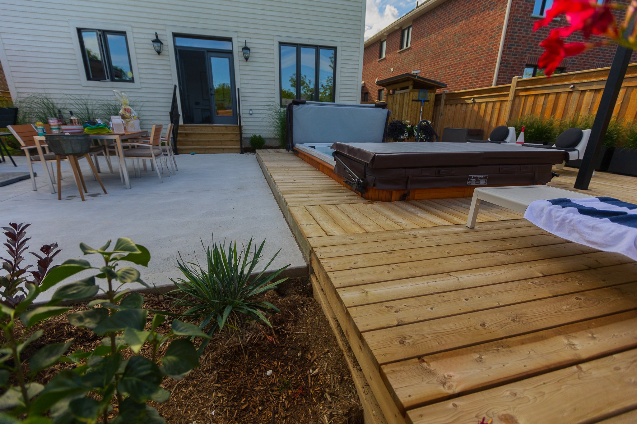 Backyard patio with wooden deck and hot tub