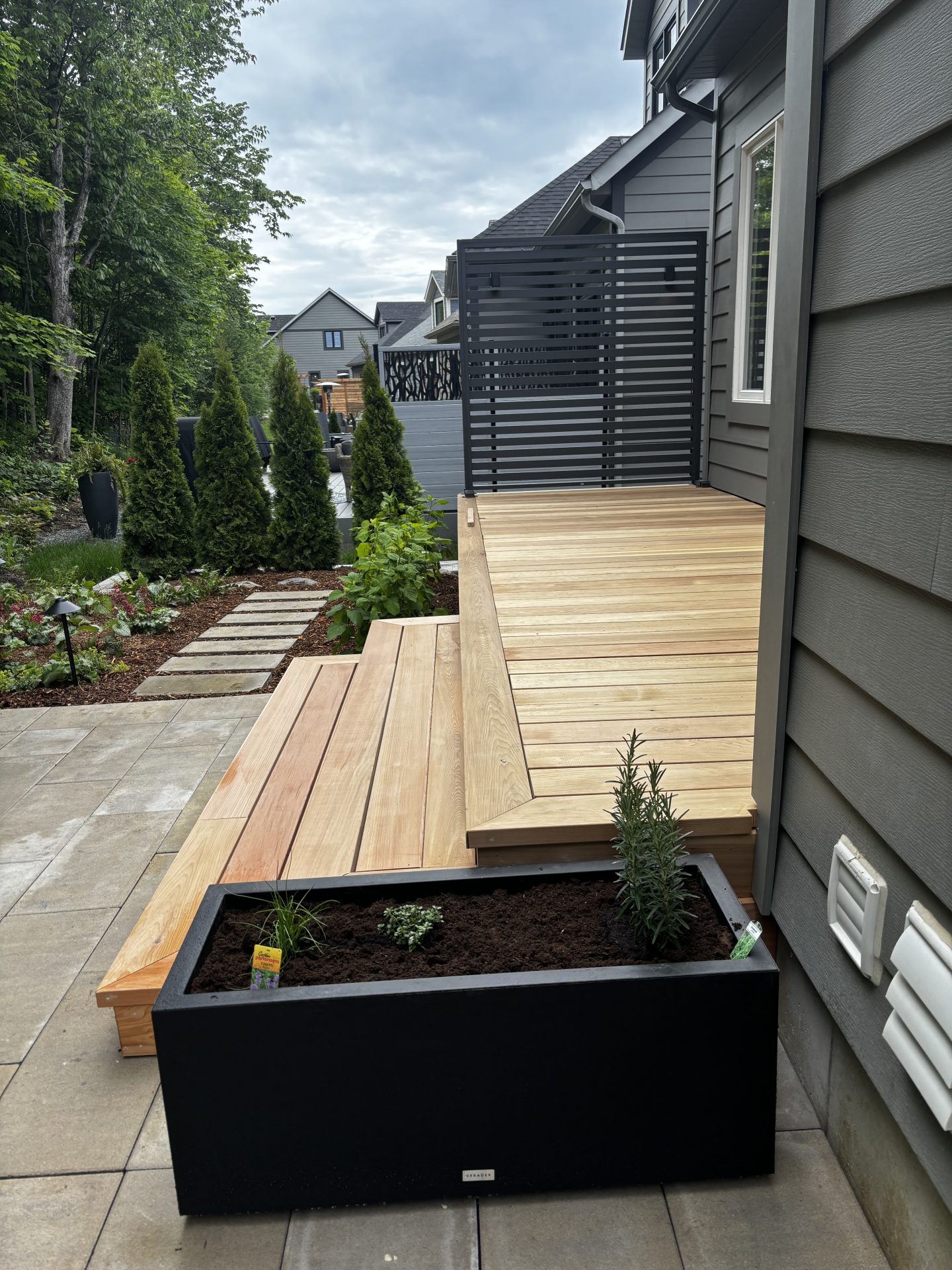 Modern backyard deck with planter and privacy screen