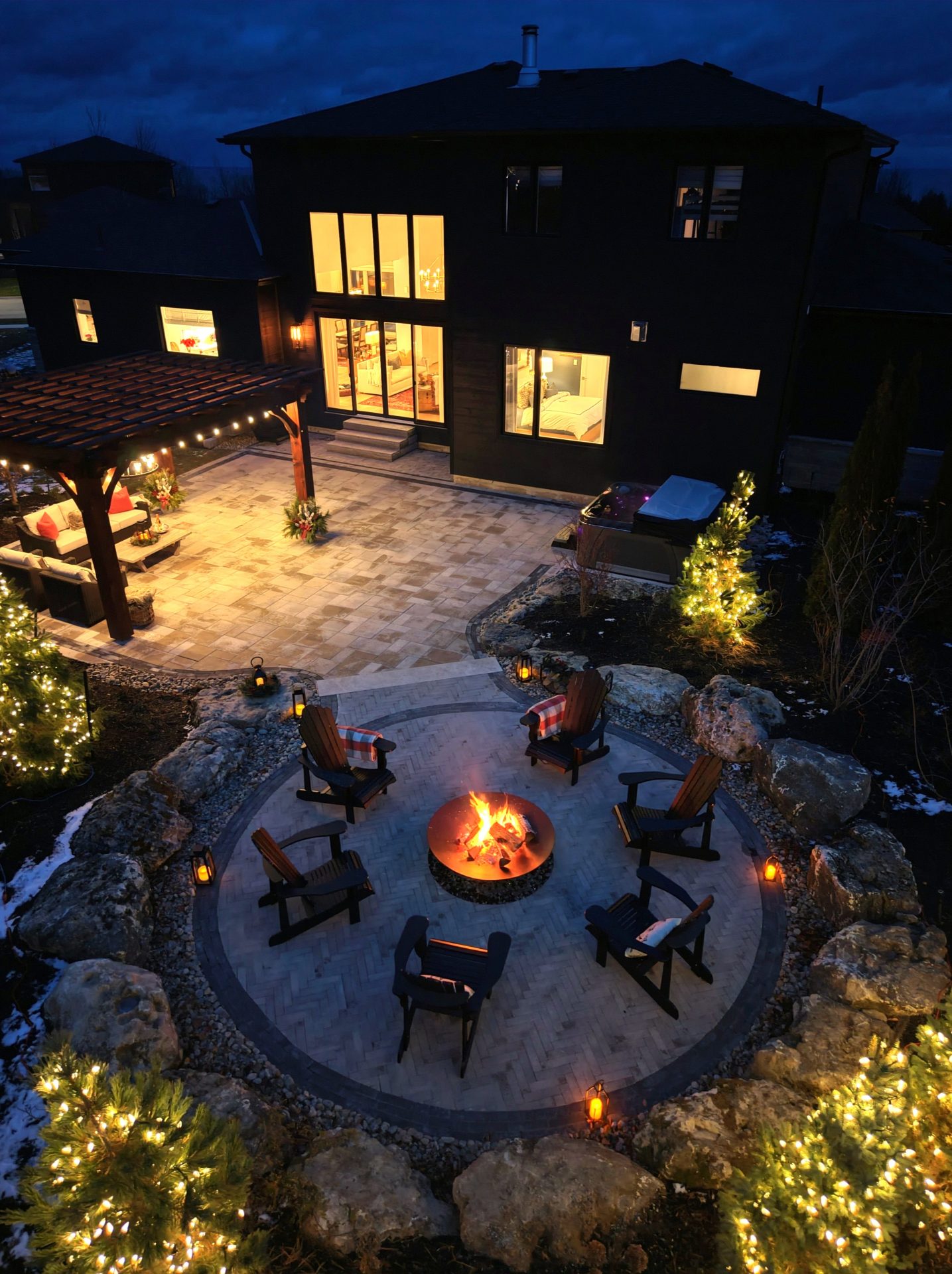 Modern backyard patio with fire pit at night