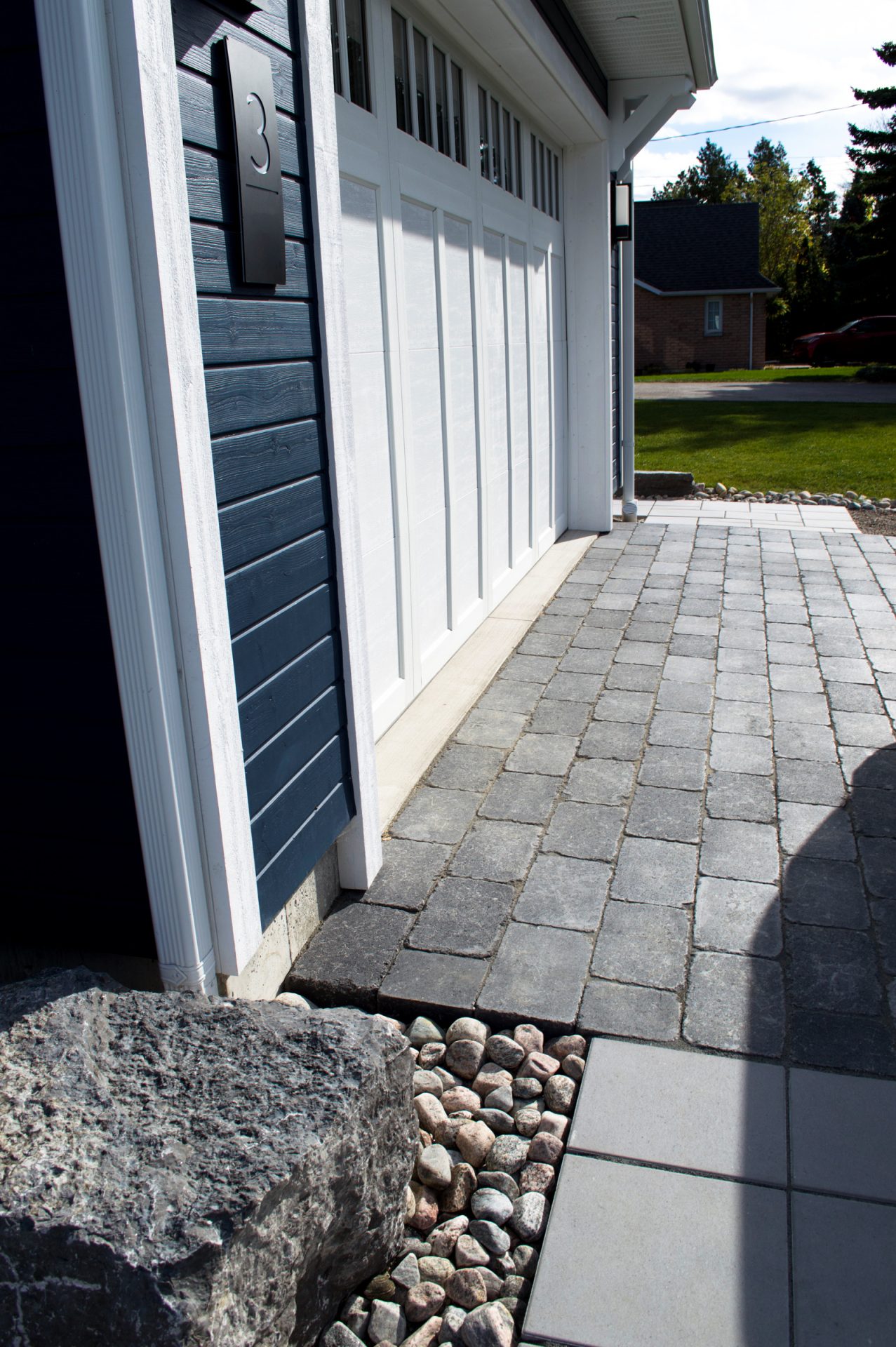 Modern garage with stone paver driveway