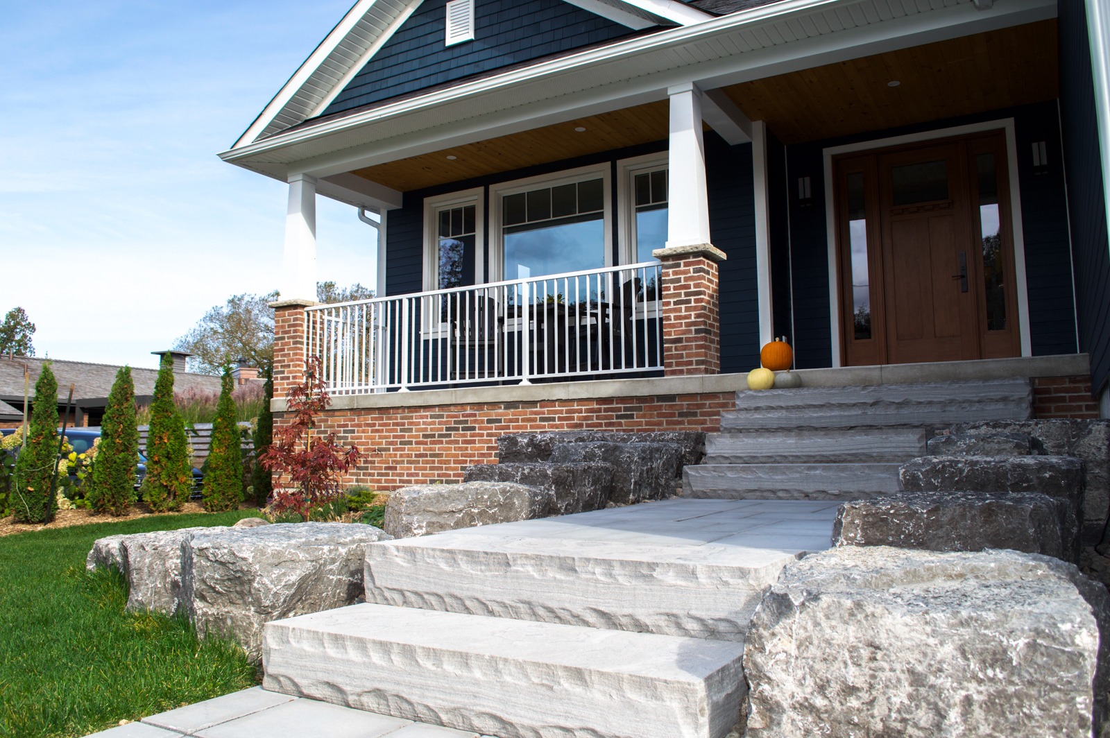 Modern home porch with stone steps and pumpkins