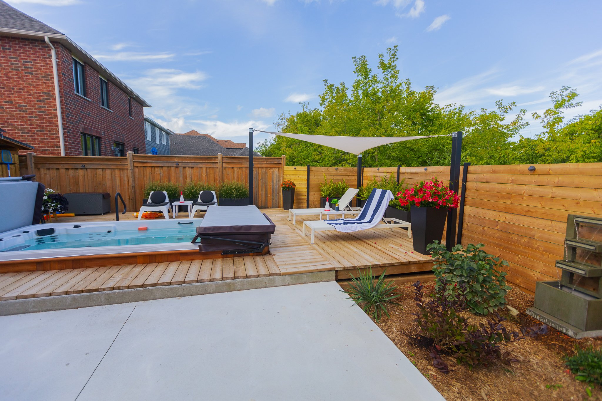Modern backyard deck with hot tub and loungers