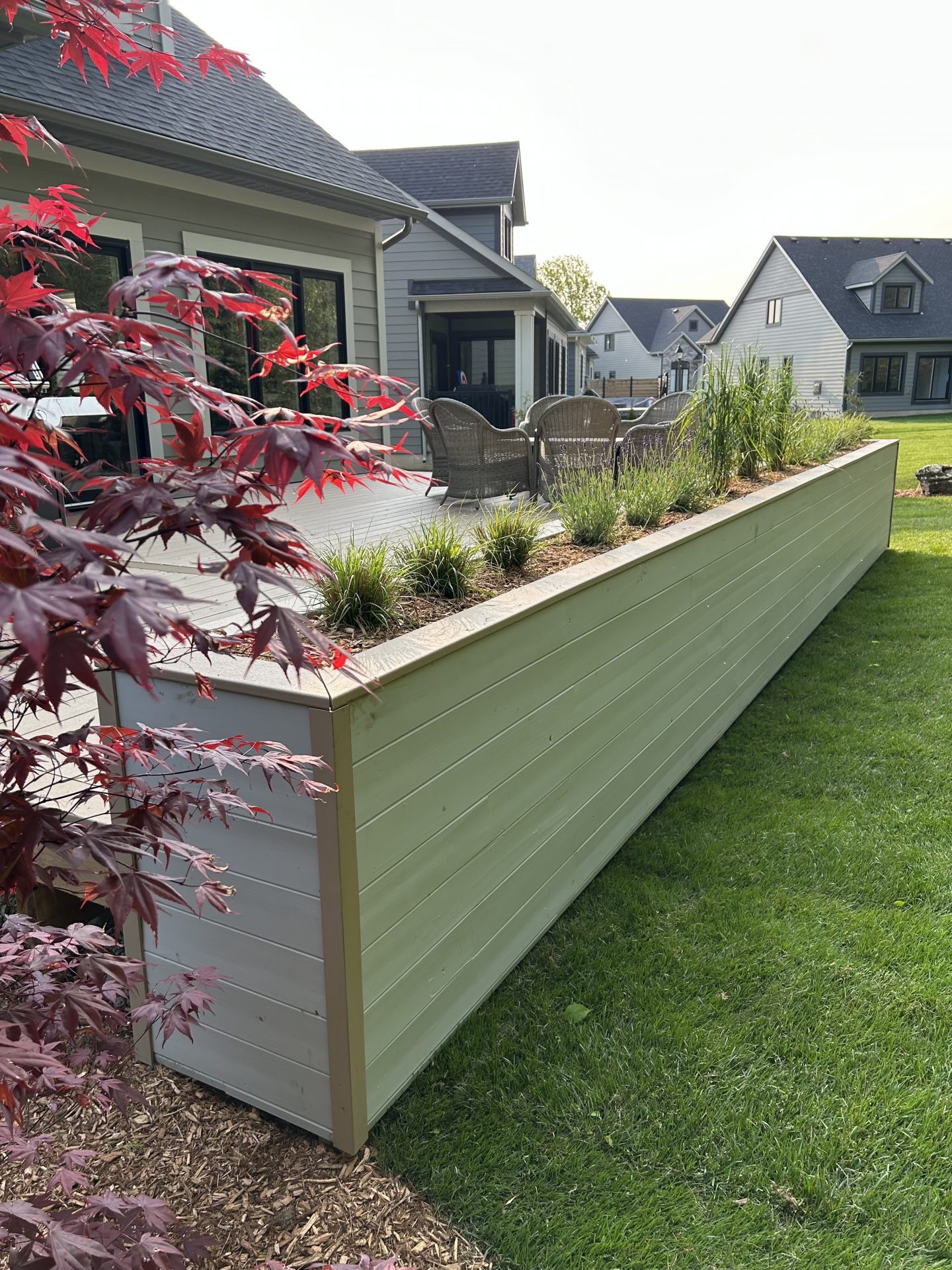Backyard patio with raised planter and lawn