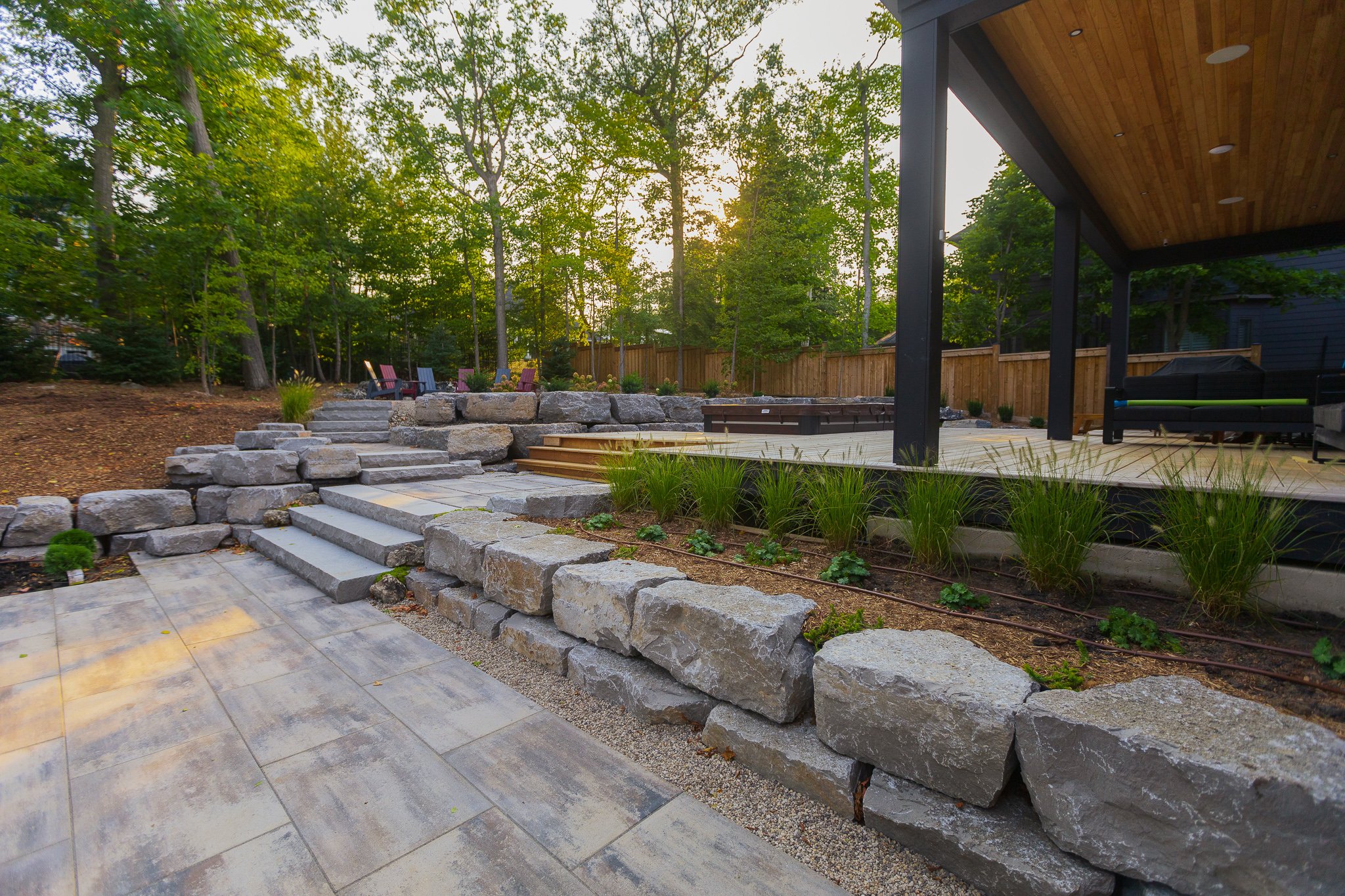 Landscaped backyard with stone steps and wooden deck