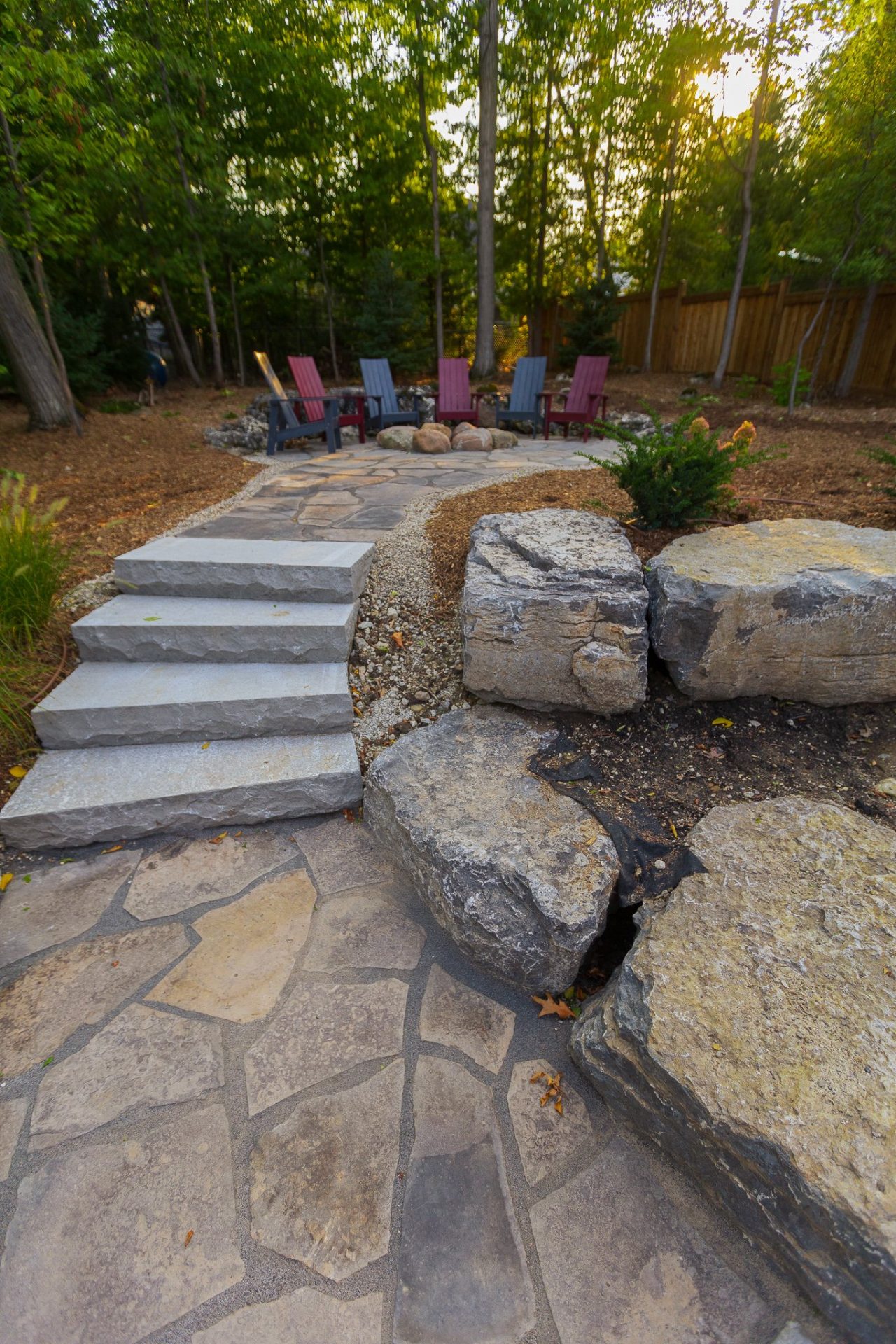 Stone patio with Adirondack chairs and fire pit
