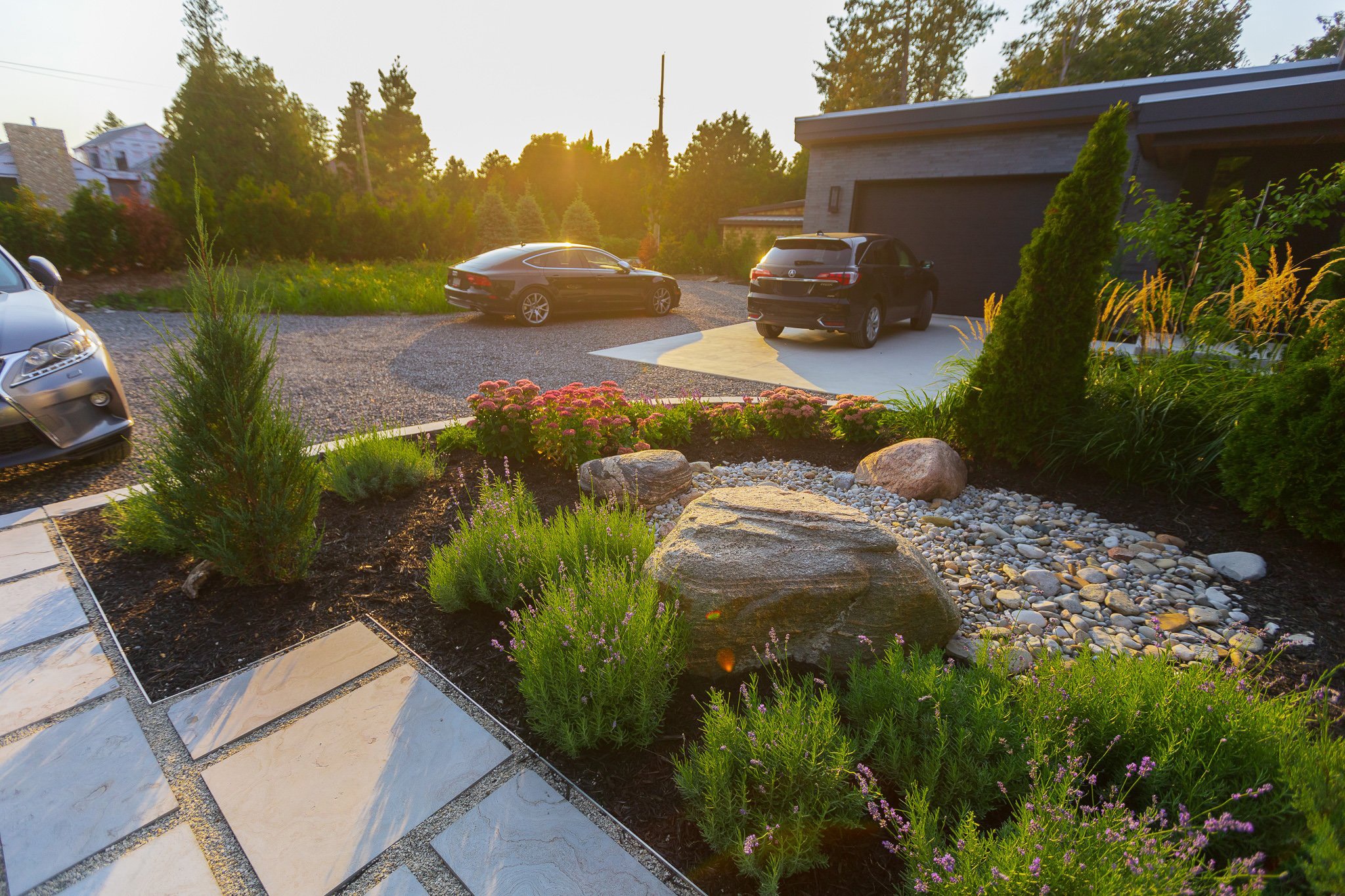 Modern home driveway with landscaped garden at sunset