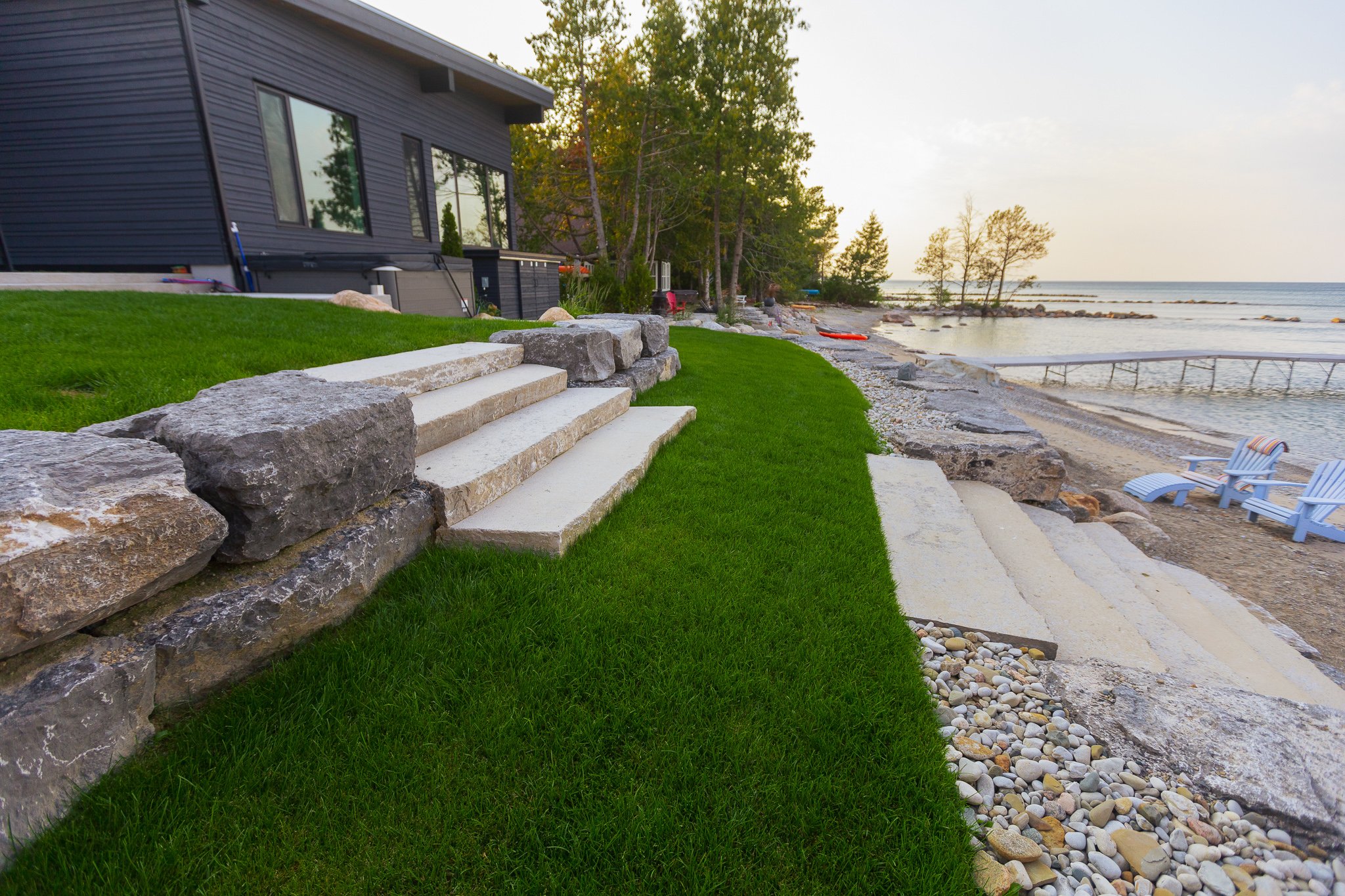 Modern lakeside home with stone steps and beach