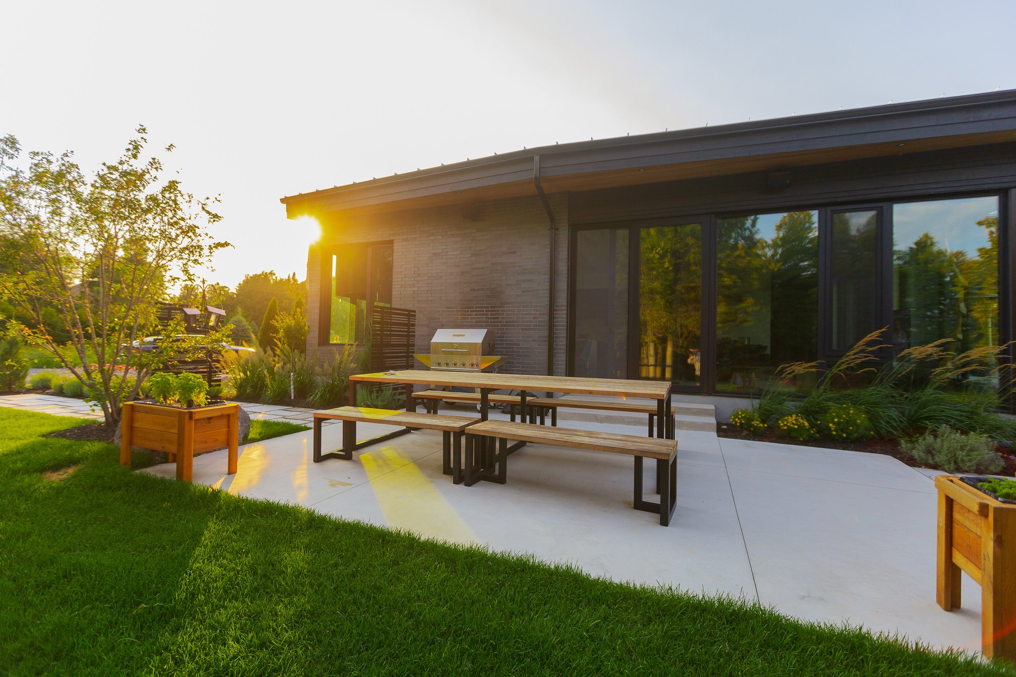 Modern backyard patio with picnic table at sunset