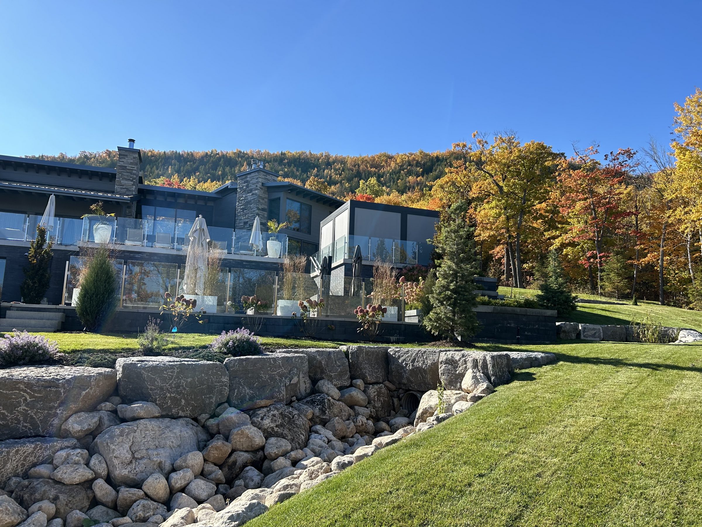 Modern hillside home with glass balcony in autumn