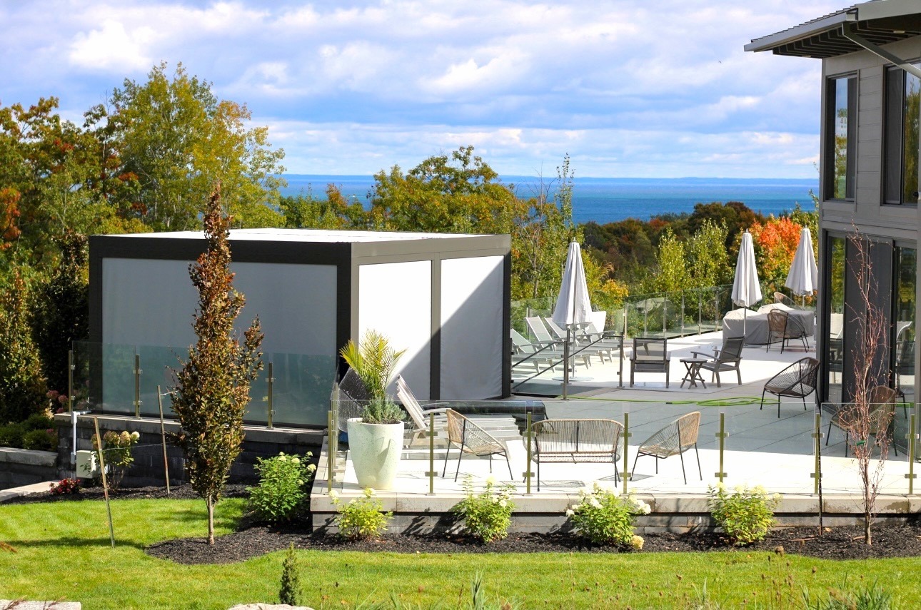 Modern lakeside terrace with glass railing and seating