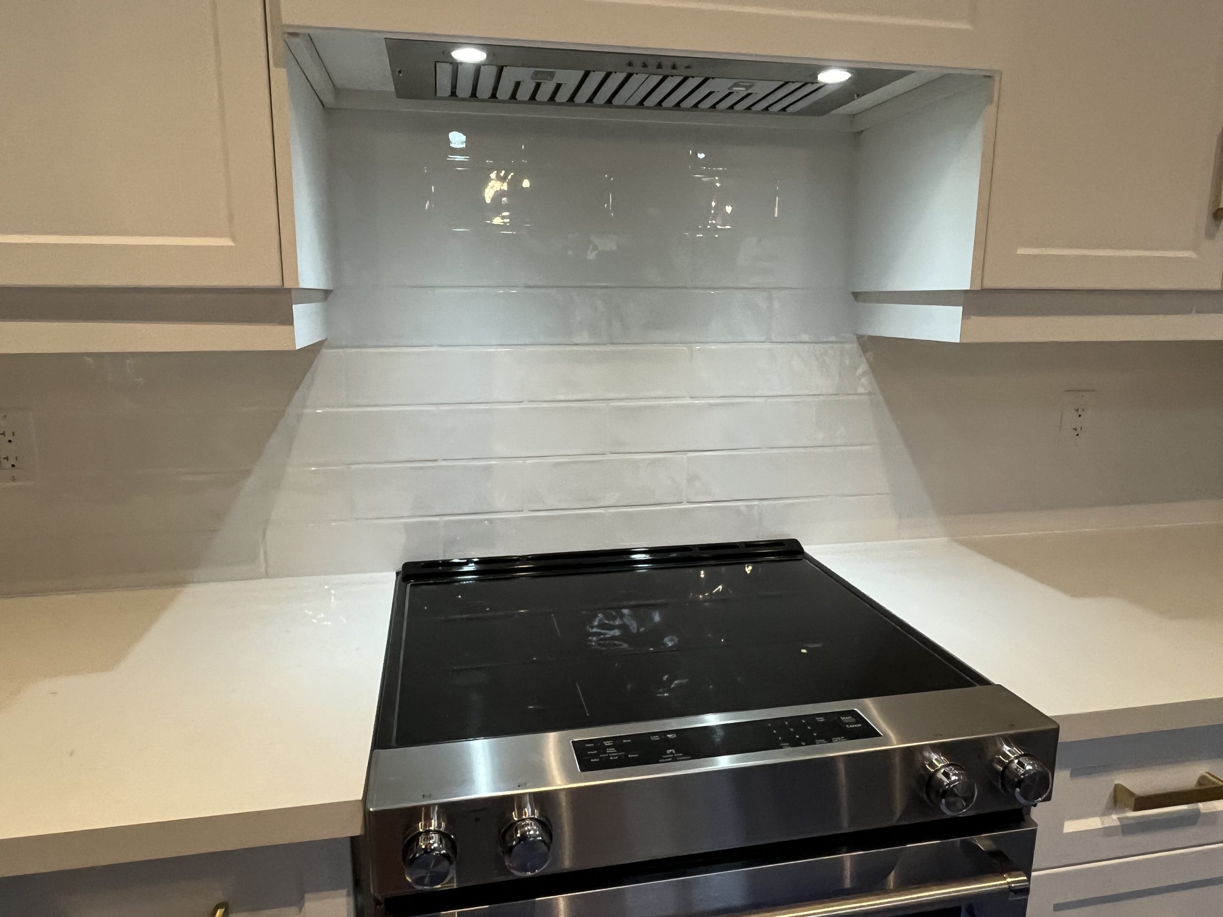 Modern kitchen stove with white tile backsplash