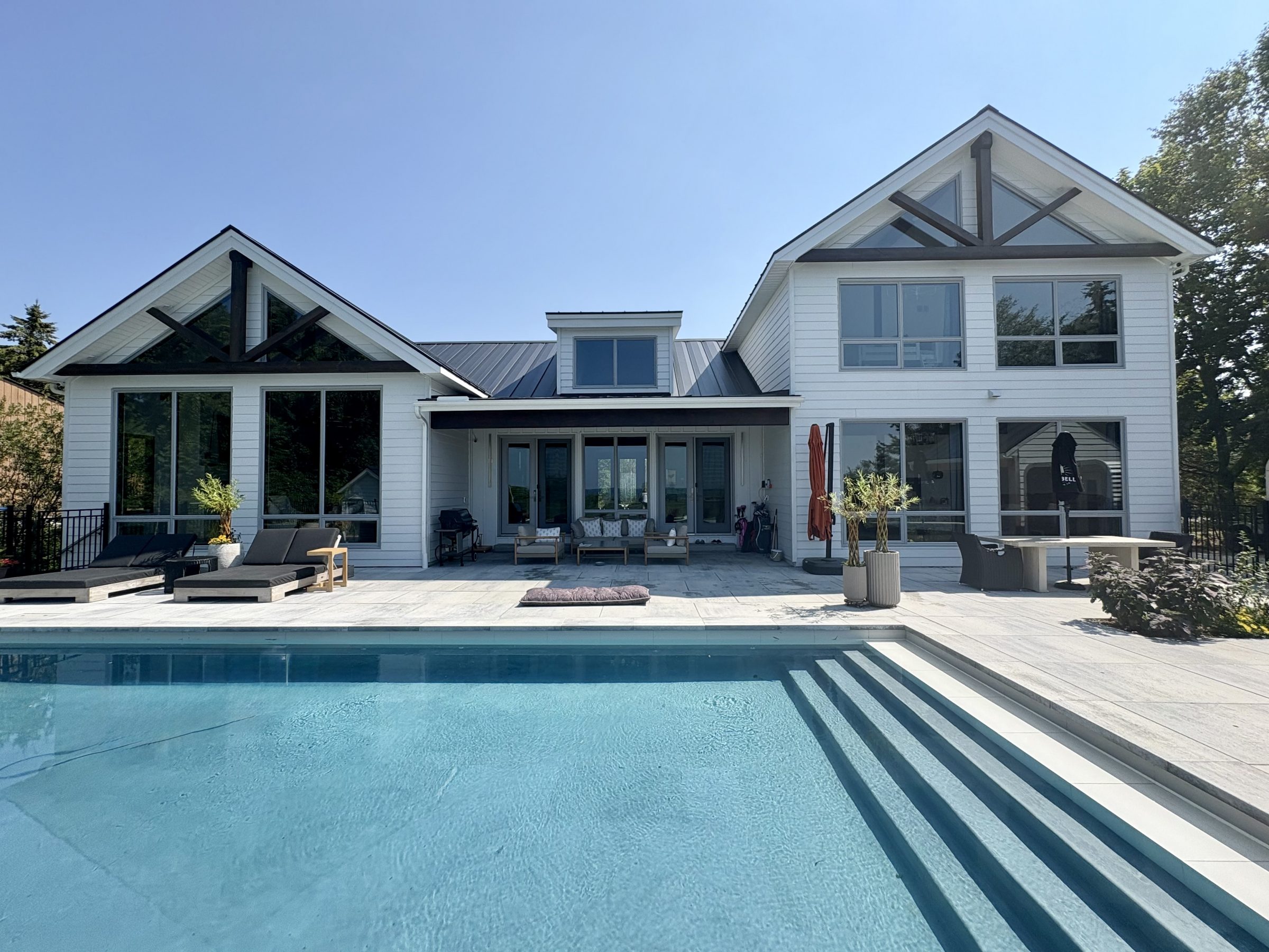 Modern white house with backyard pool and patio