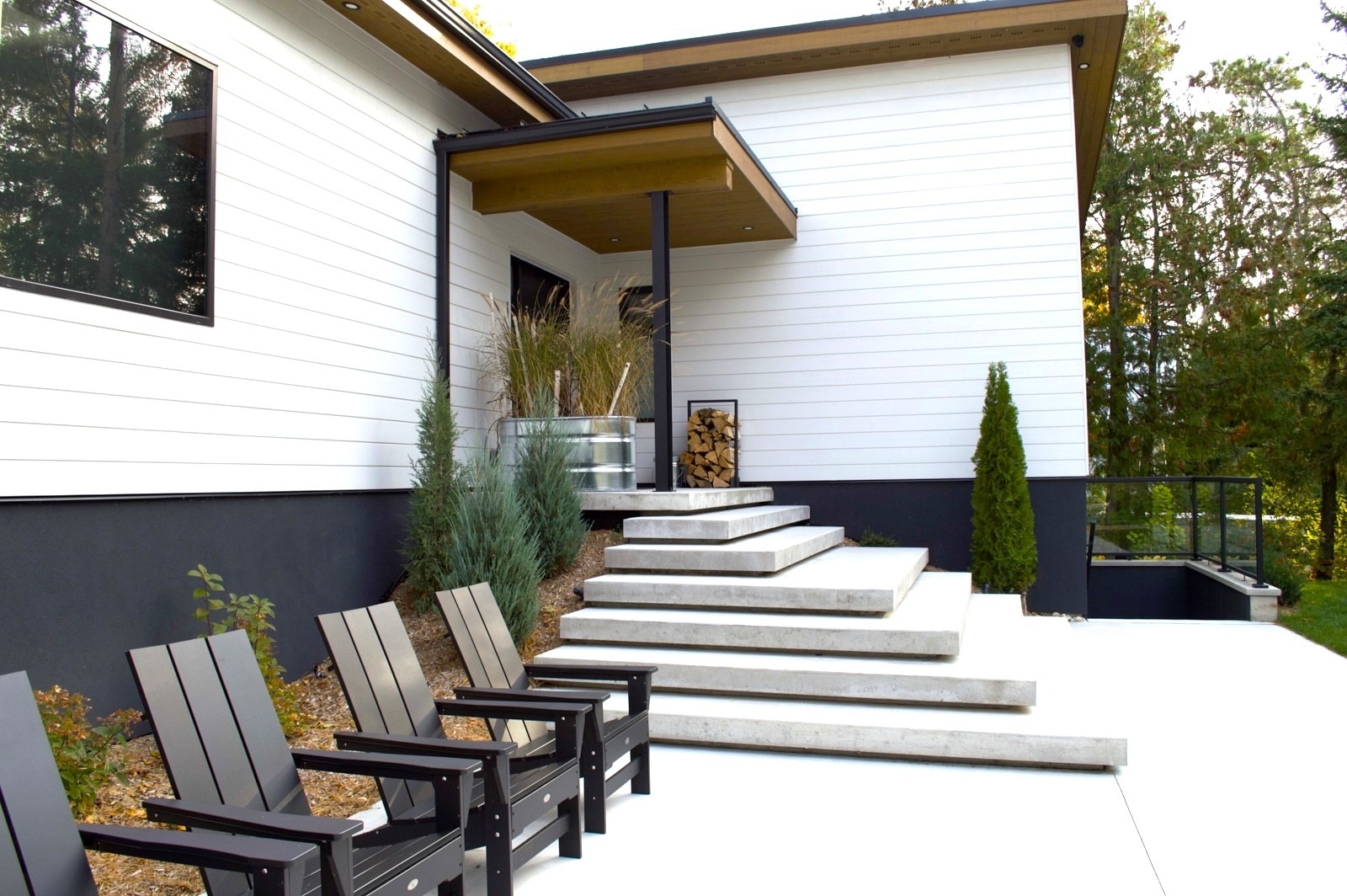 Modern white home with concrete steps and chairs