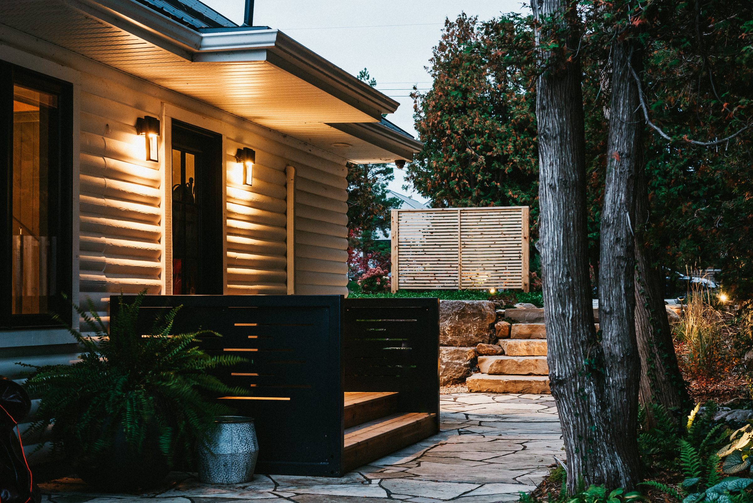 Cozy house exterior with warm lights at dusk