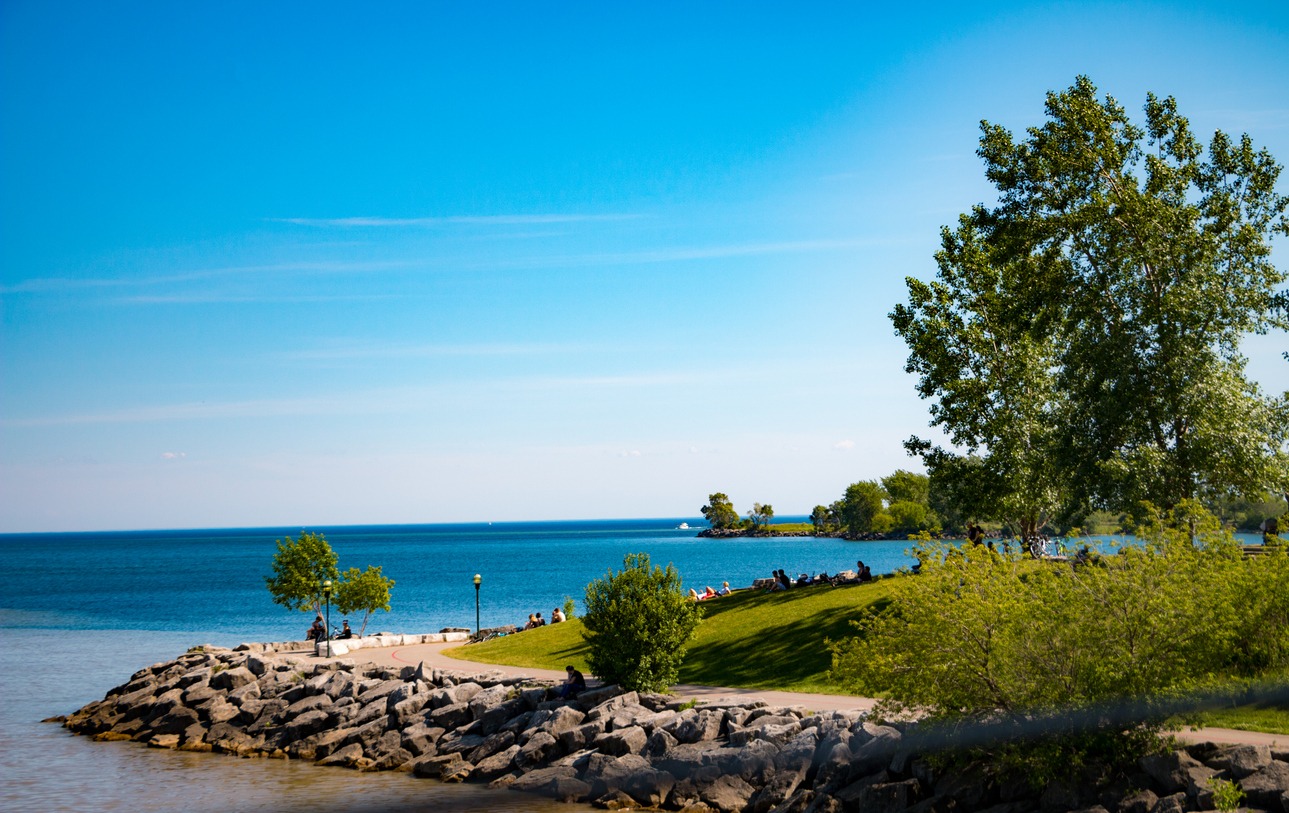 Lakeside park with rocky shore and grassy hill