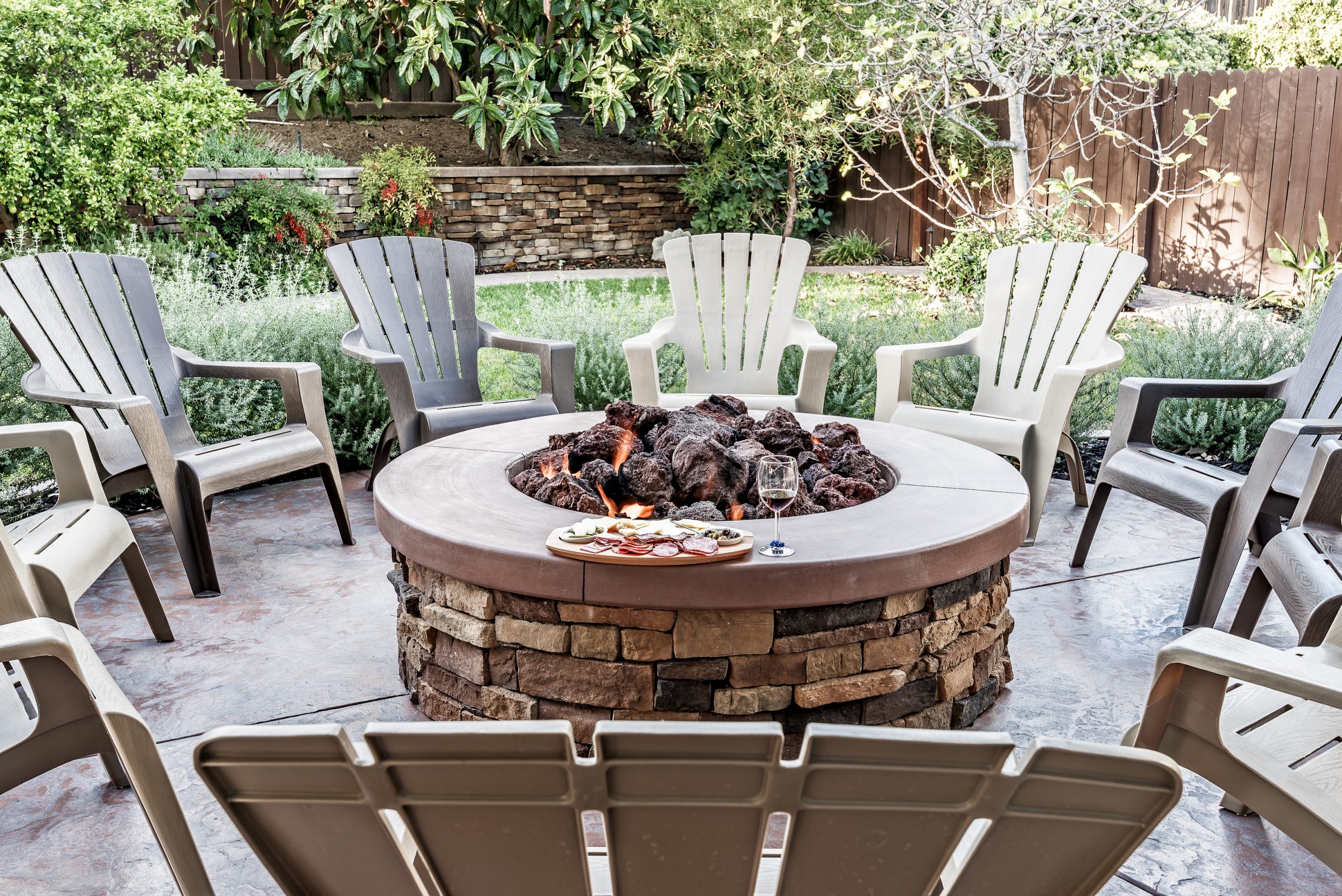 Backyard patio with fire pit and Adirondack chairs