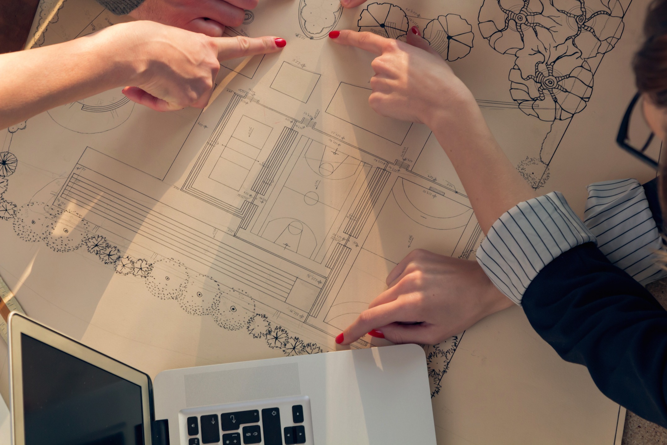 Two people reviewing architectural blueprint plans together