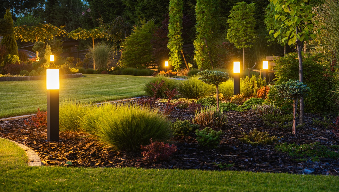Modern garden pathway illuminated by outdoor bollard lights