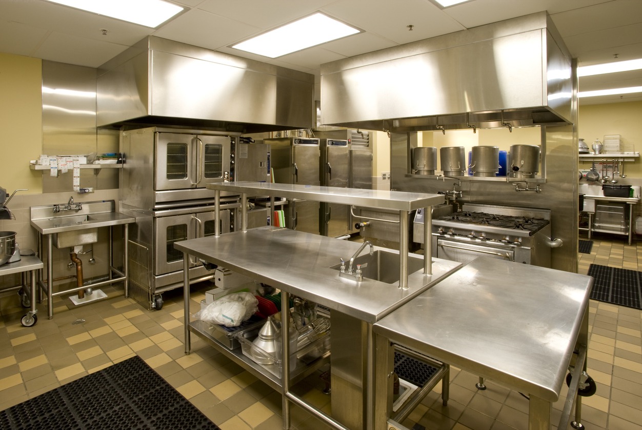 Commercial stainless steel kitchen with ovens and prep tables