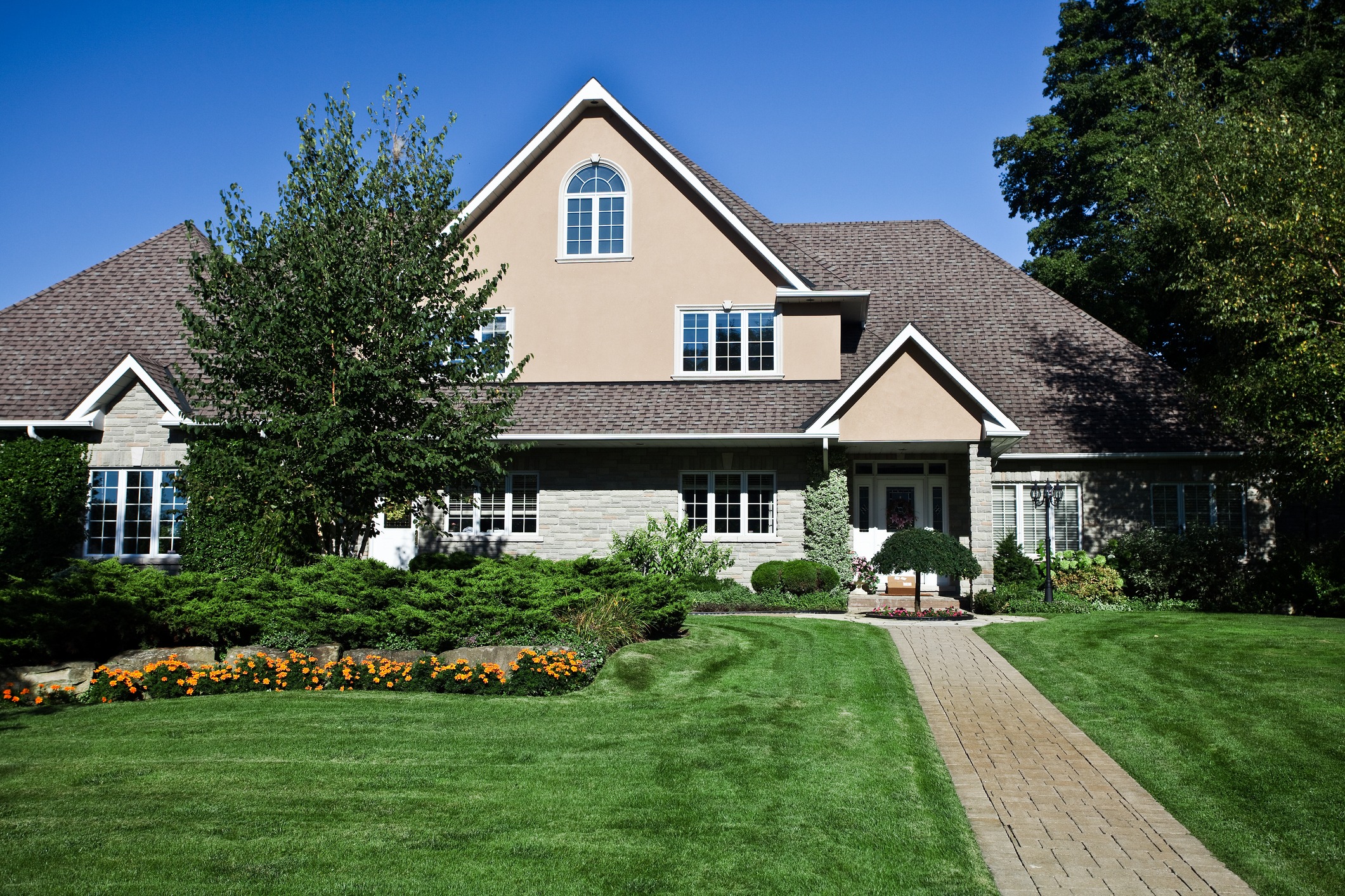 Large suburban house with manicured lawn and garden