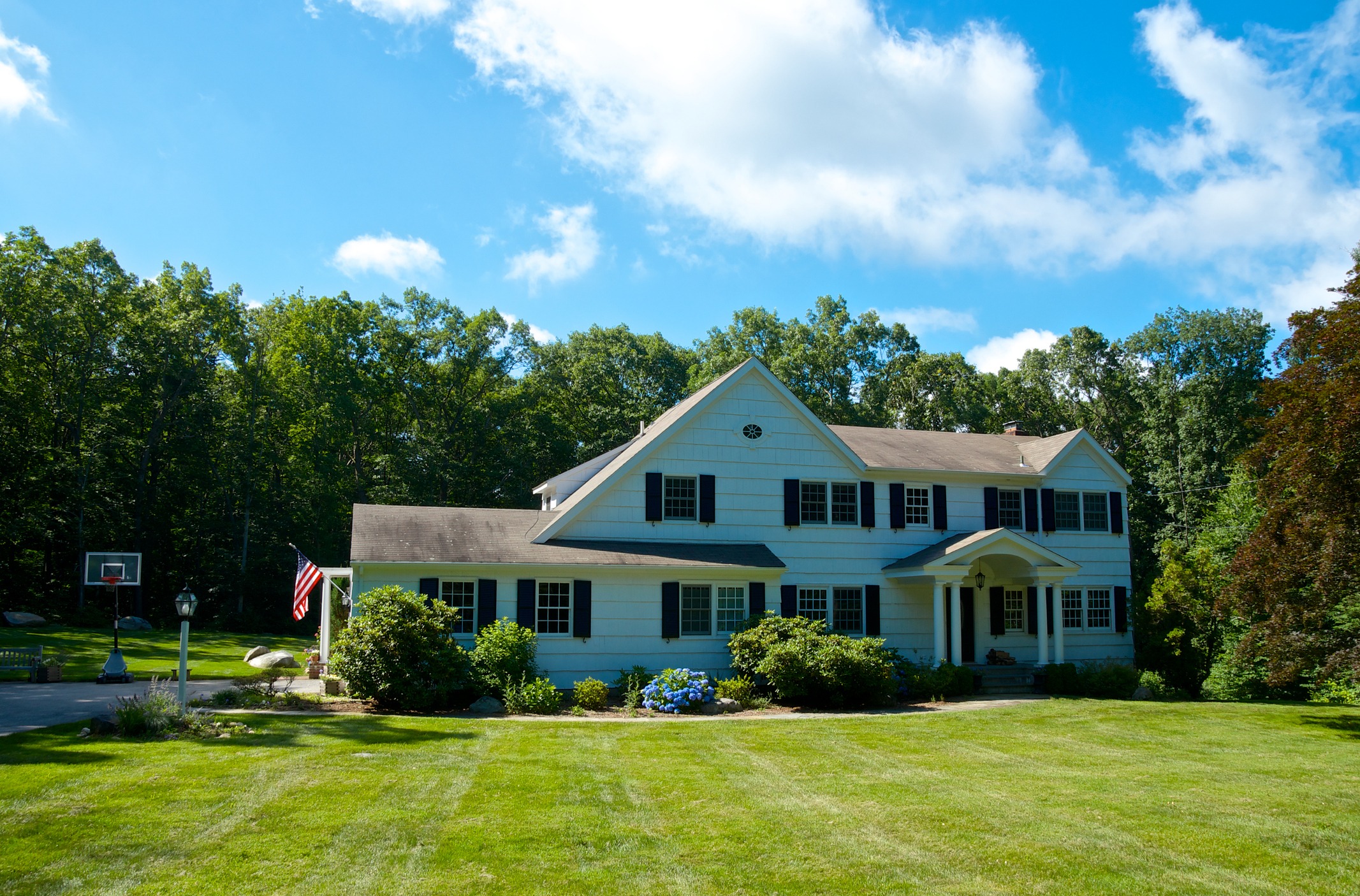 White two-story suburban home with large lawn