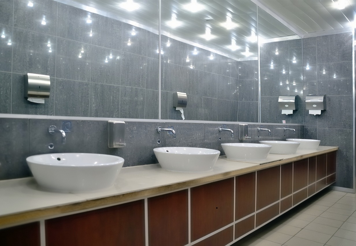 Modern public restroom with multiple white sinks