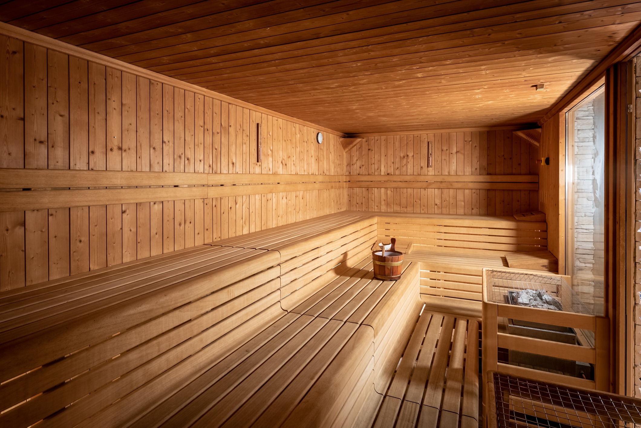 Wood-lined sauna interior with benches and heater