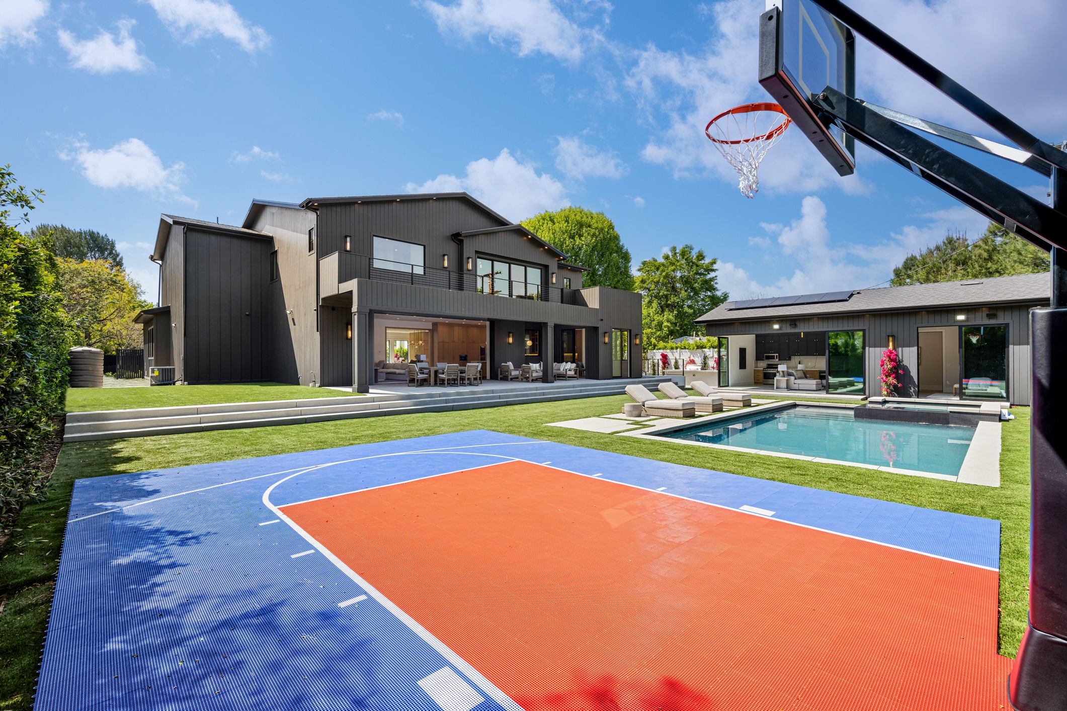 Modern home backyard with pool and basketball court