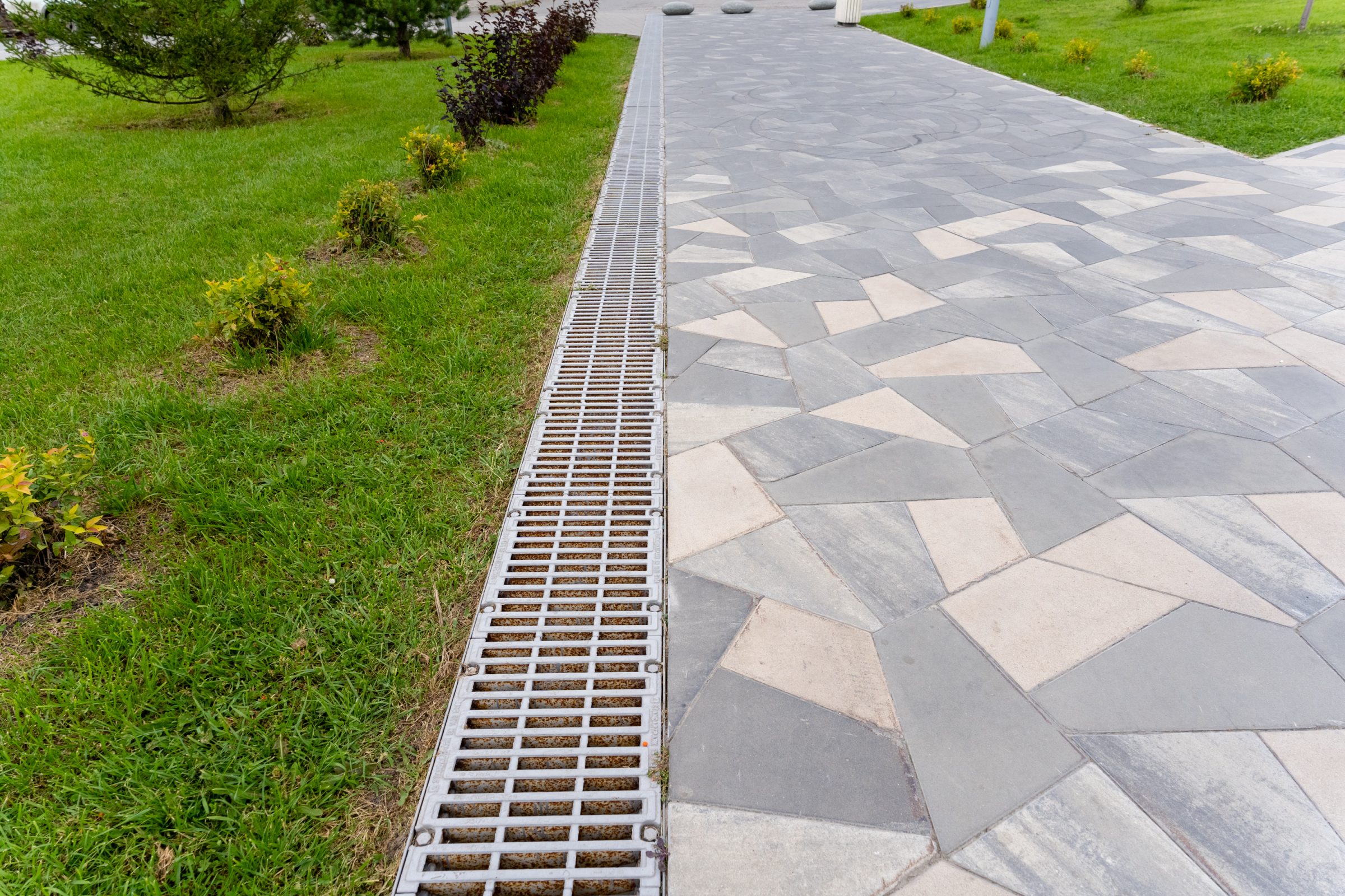 Paved walkway with drainage grate and grass border