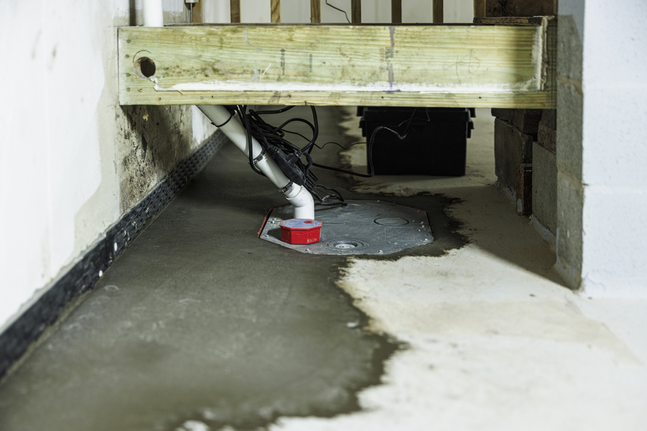 Basement sump pump with water pooling on floor