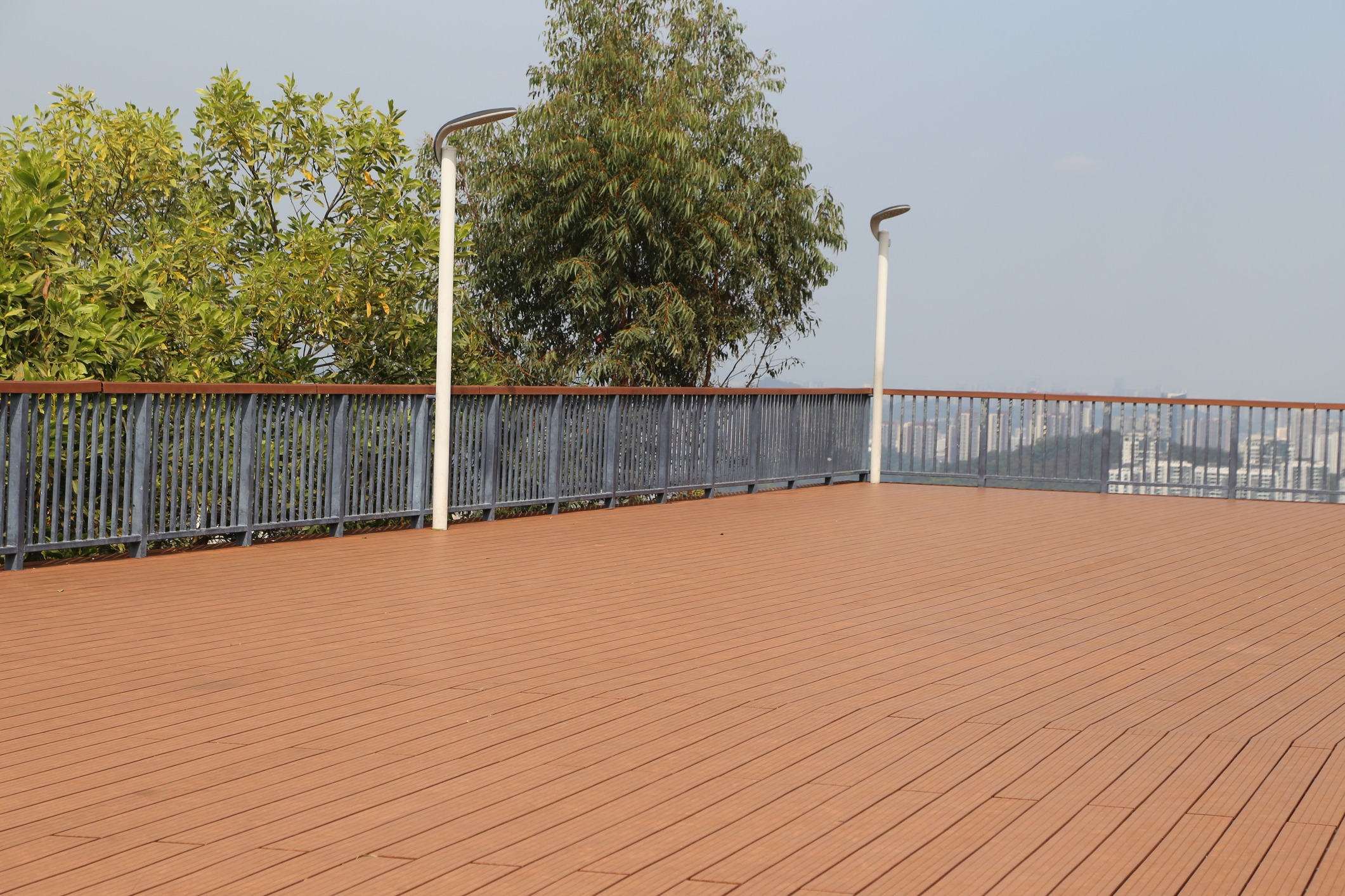 Empty wooden rooftop deck with city skyline view