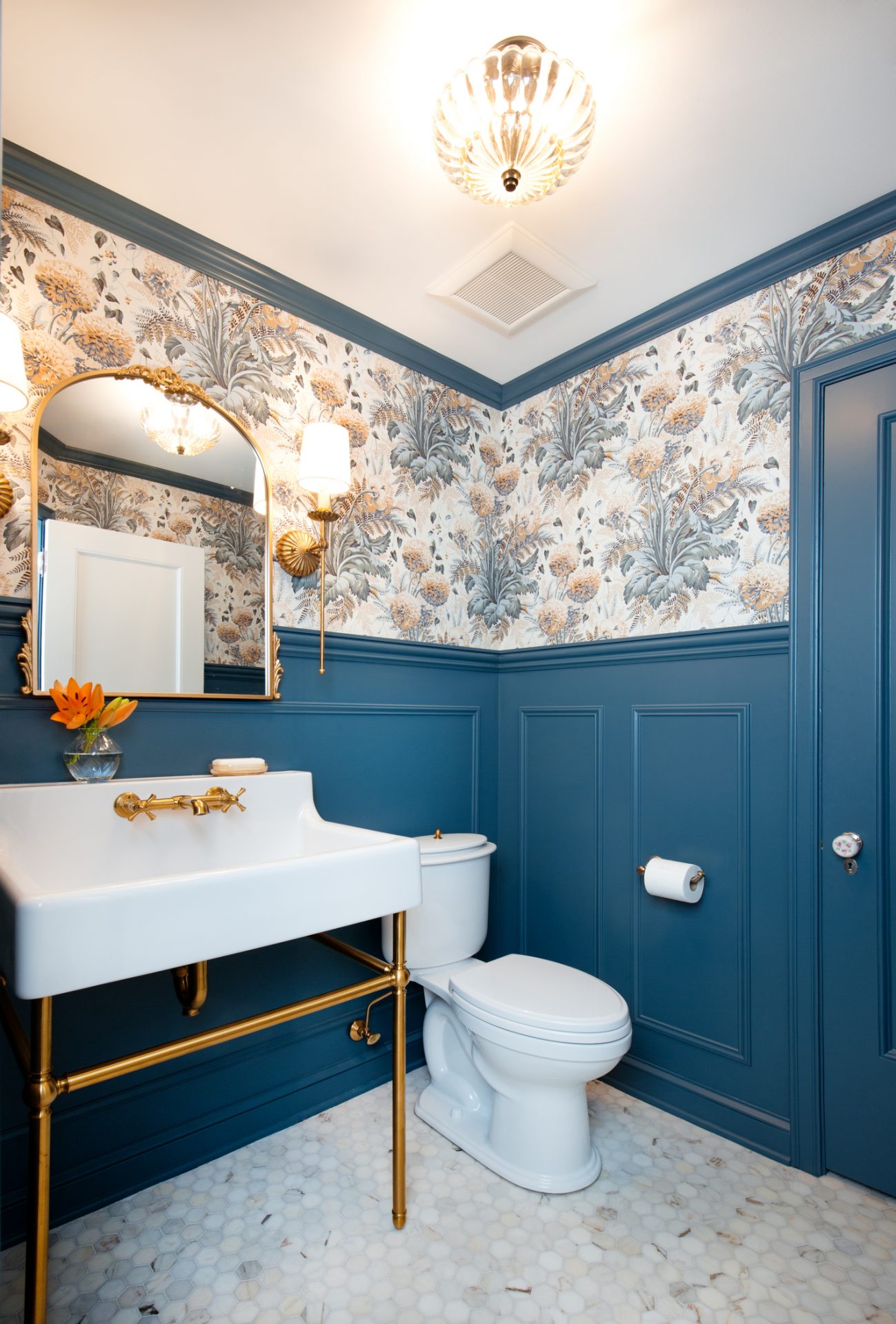 Elegant bathroom with teal paneling and floral wallpaper