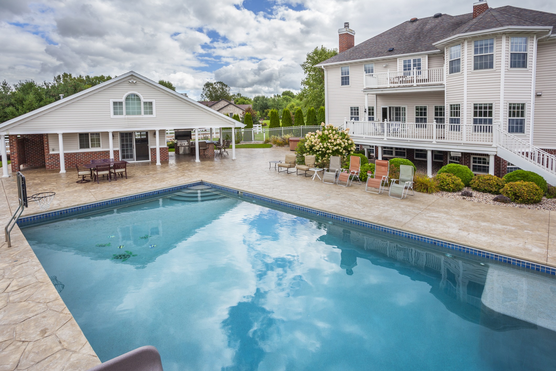 Large backyard pool beside two-story suburban home