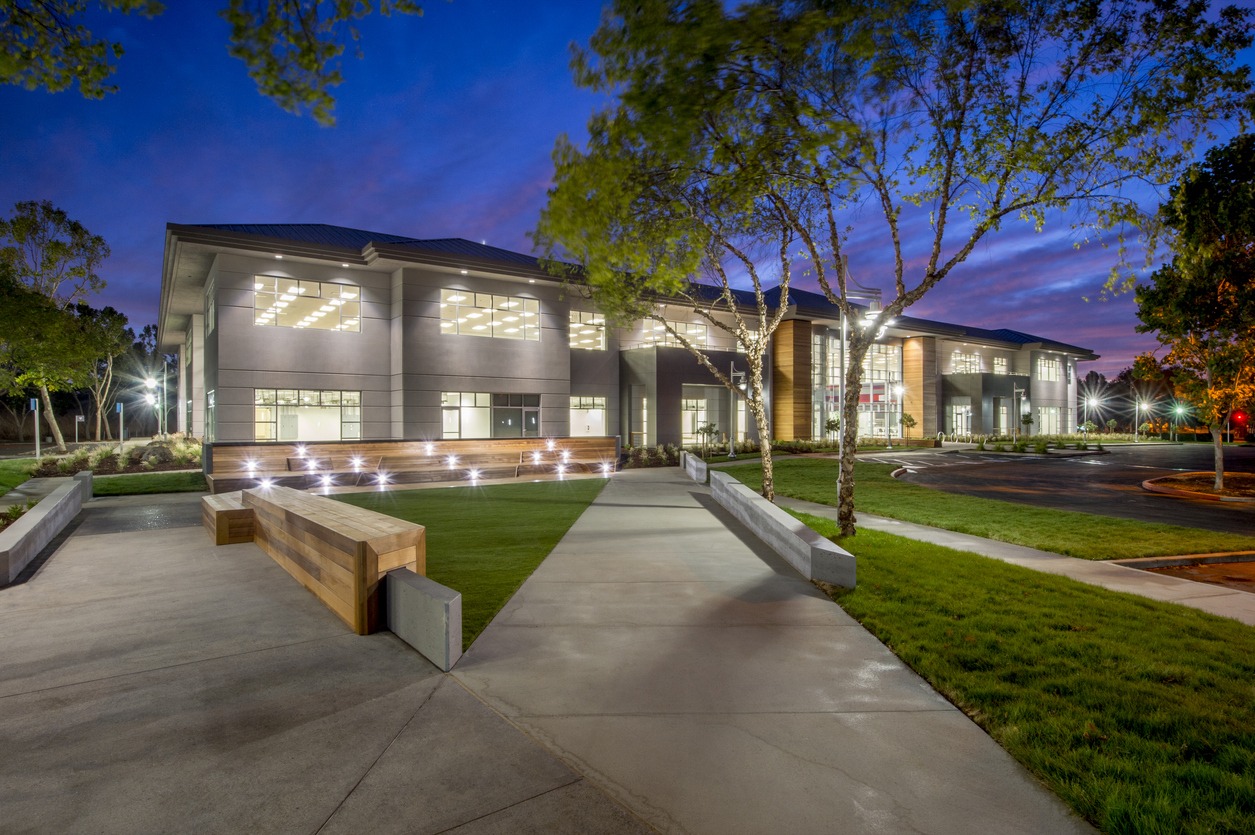 Modern office building at dusk with landscaped walkway