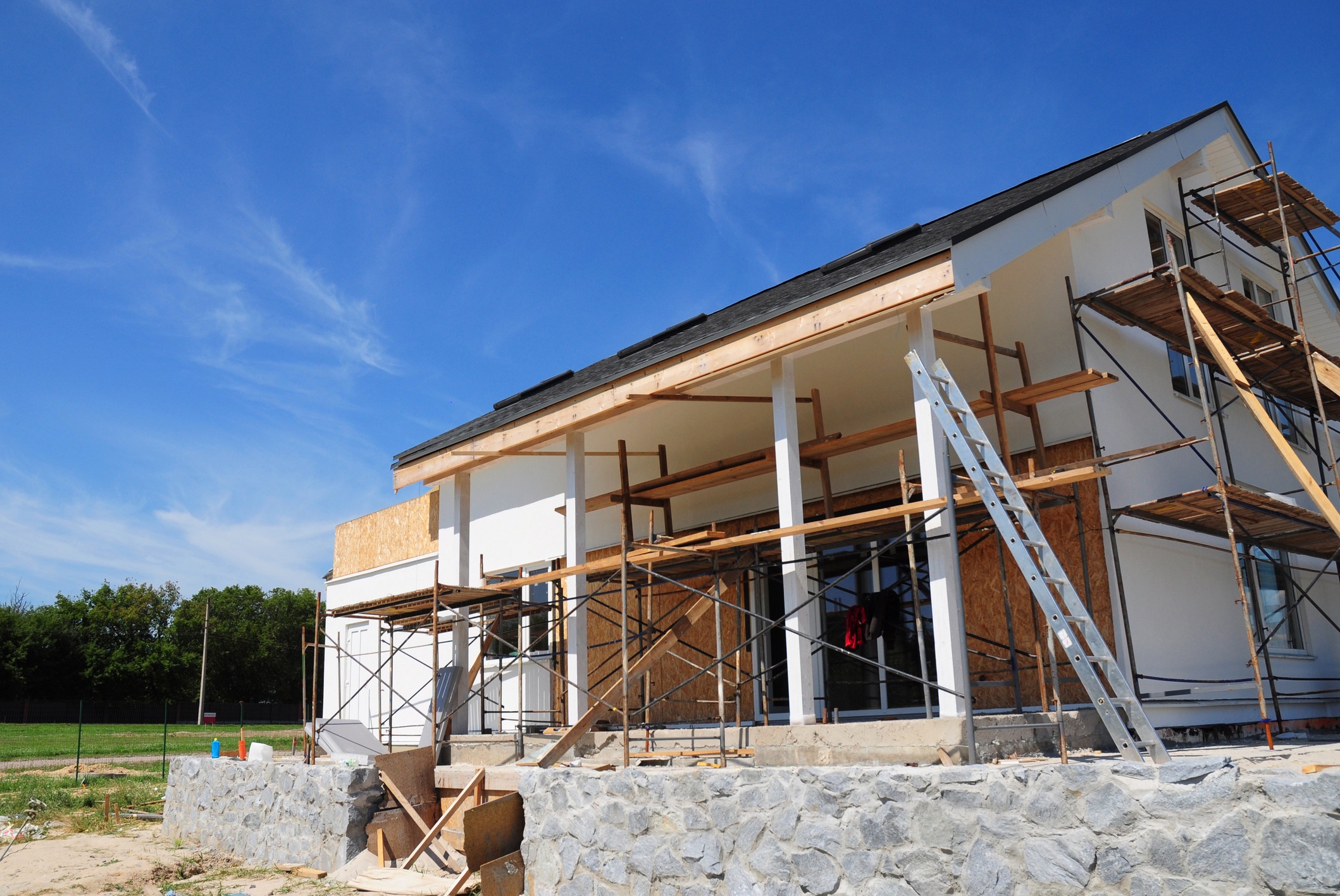 House under construction with scaffolding and ladder