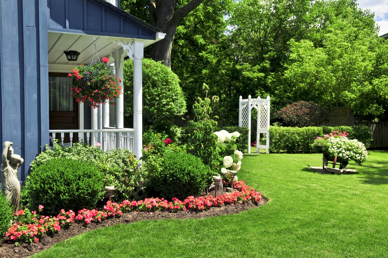 Manicured garden with porch, flowers, and white arbor