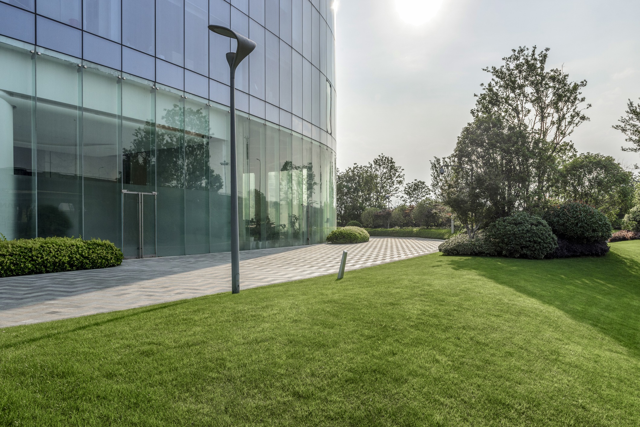 Modern glass office building with landscaped lawn